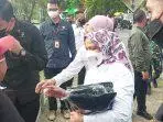 Ibu Iriana Joko Widodo turun dari mobil bagi buku tulis dan baju Jokowi di Kantor Pos Tual